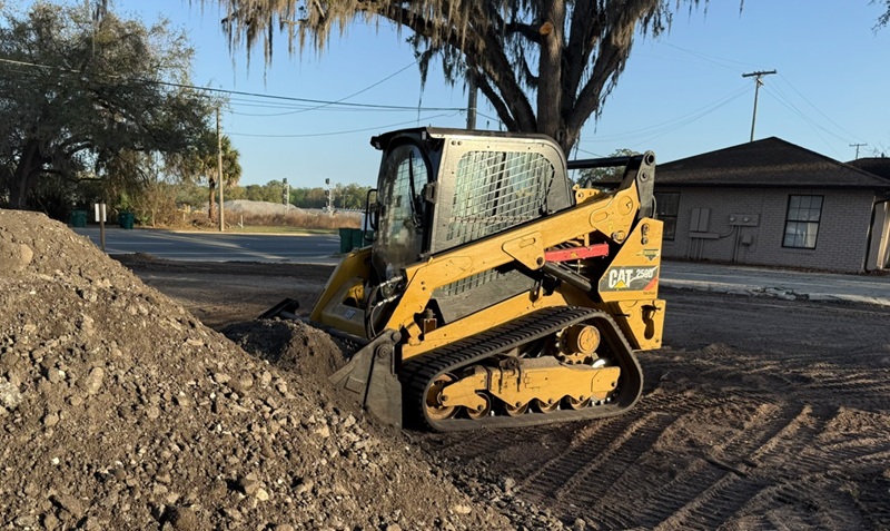 Residential forestry mulching machine clearing dense backyard vegetation and small trees on a Central Florida residential property to create clean, usable outdoor space.