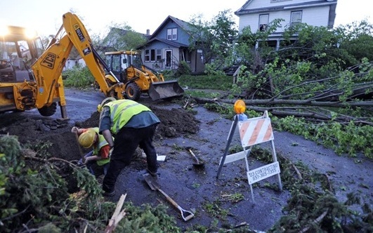 Storm cleanup crew clearing large fallen trees and broken limbs from a storm damaged Central Florida property to restore access and remove dangerous hazards.