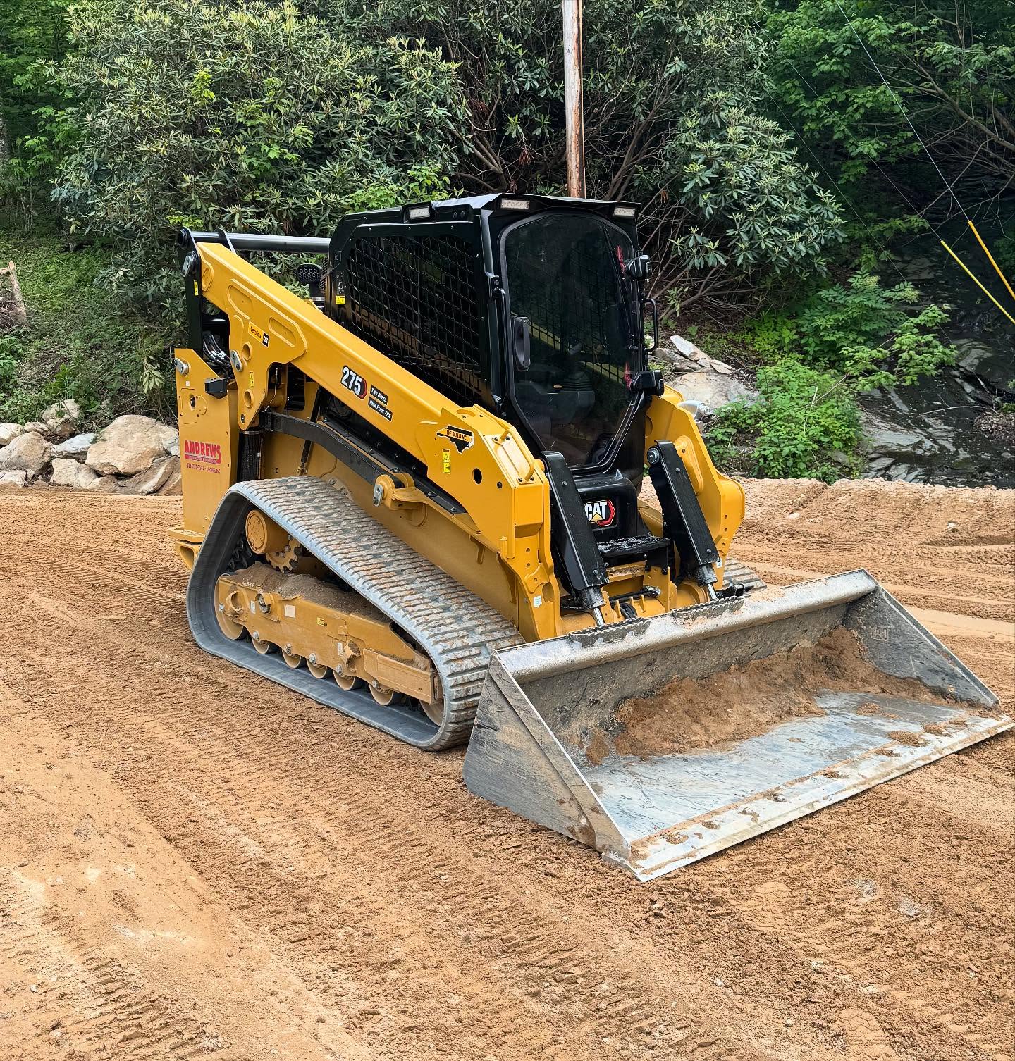 Operator grading uneven homesite soil for future driveway and building pad preparation